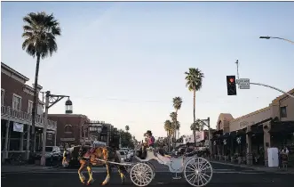  ?? CAITLIN O’HARA/ FOR WASHINGTON POST PHOTOS: ?? A Scottsdale Carriage Company driver gives tourists a sunset spin through Old Town Scottsdale, Ariz.