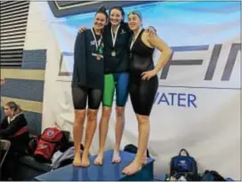  ??  ?? From left, Notre Dame’s Michael McGeary and Episcopal Academy’s Emma Seiberlich and Maddie O’Reilly pose with their medals in the 100 freestyle at Easterns. Seiberlich won, McGeary was third and O’Reilly eighth.