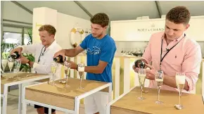  ??  ?? All Blacks Damian McKenzie, left, and Beauden Barrett, right, take on Spanish tennis player Pablo Carreno Busta in a champagne pouring competitio­n at the ASB Classic yesterday.