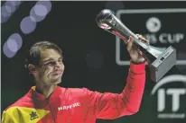  ?? MANU FERNANDEZ/ASSOCIATED PRESS ?? Rafael Nadal holds the tournament’s best player award after Spain defeated Canada in the Davis Cup final Sunday in Madrid, Spain.