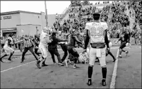  ?? Cassie Soto Las Vegas Review-Journal ?? Players from both teams scuffle in the south end zone of Mackay Stadium and near the UNR sideline after the Rebels’ OT victory.