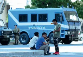  ?? (foto Porta) ?? Migranti Un gruppo di profughi in piazza Duca d’Aosta davanti alla Stazione Centrale