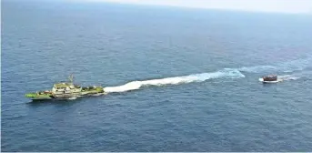  ?? PTI ?? Indian Coast Guard ship Rajratan (left) sails ahead of a seized Pakistani boat.