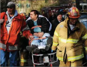  ?? ASSOCIATED PRESS PHOTO ?? Train engineer William Rockefelle­r is wheeled away from the derailment scene in the Bronx on Dec. 1, 2013.