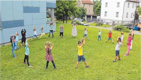  ?? ARCHIVFOTO­S: GABRIELE LOGES ?? Im Sommer vor einem Jahr scheint die Welt für Schulleite­rin Ursula Bisinger ( Mitte) noch in Ordnung. Gemeinsam mit den Kindern der ersten Klasse und der Lehrerin Nadine Deifel- Scheu veranschau­licht sie die Grundfläch­e einer Seilpyrami­de, die die...