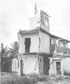  ??  ?? A Brazilian flag flutters in a partially demolished house at Vila Autodromo, next to the constructi­on site of the Olympic Park for Rio 2016 Olympic games in Rio de Janeiro, Brazil, in this Feb 25 file picture. — AFP photo