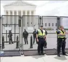  ?? Jacquelyn Martin/Associated Press ?? Authoritie­s stand guard by a fence outside the Supreme Court on Friday after its decision to overturn Roe v. Wade in Washington.