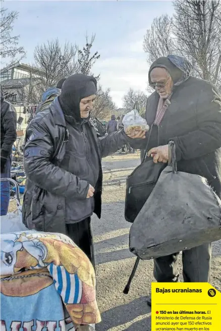  ?? Foto: Efe ?? Dos ancianos ucranianos recogen alimentos en Járkov.
