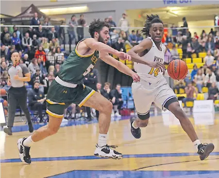  ?? ADRIAN LAM, TIMES COLONIST ?? University of Victoria Vikes’ Renaldo Robinson drives on Regina Cougars’ Nick Barnard during their Canada West men’s playoff quarter-final at CARSA on Saturday night.