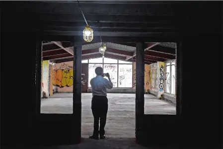  ?? PHOTOS BY SEAN D. ELLIOT THE DAY ?? Above, DEEP spokesman Chris Collibee takes photos Monday inside the main hospital building of the former Seaside Regional Center in Waterford. Potential developers and other interested parties toured the historic Cass Gilbert buildings at the former...