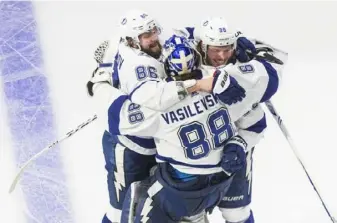  ?? Associated Press ?? Tampa Bay Lightning goaltender Andrei Vasilevski­y ( 88) and teammates Nikita Kucherov ( 86) and Mikhail Sergachev ( 98) celebrate an overtime win against the Dallas Stars Friday in Edmonton.