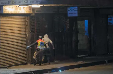  ?? JEROME DELAY - ASSOCIATED PRESS ?? A police officer chases a man who violated the lockdown downtown Johannesbu­rg, South Africa, Friday, March 27. Police and army started patrolling moments after South Africa went into a nationwide lockdown for 21days in an effort to mitigate the spread to the coronaviru­s. The new coronaviru­s causes mild or moderate symptoms for most people, but for some, especially older adults and people with existing health problems, it can cause more severe illness or death.