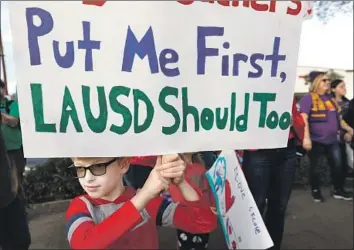  ?? Francine Orr Los Angeles Times ?? GAVIN McKEAN, 9, joins about 200 people at a Friday rally for teachers in a contract standoff with the L.A. Unified School District. Teachers could go on strike Monday, the first walkout in nearly 30 years.