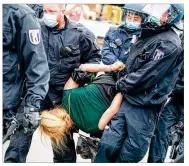  ?? CHRISTOPH SOEDER / DPA VIA AP ?? Police offifficer­s carry a woman at the Victory Columnin a protest against the coronaviru­smeasures in Berlin, Germany on Sunday.