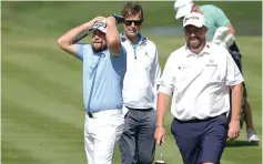  ?? (AP photo/Charlie Neibergall) ?? Tyrrell Hatton, of England, left, reacts to his shot on the fifth green Wednesday during a practice round for The Players Championsh­ip golf tournament in Ponte Vedra Beach, Fla.