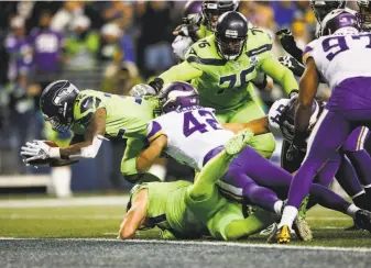  ?? Otto Greule Jr. / Getty Images / TNS ?? Chris Carson of the Seahawks dives passed Ben Gedeon (42) of the Vikings for a touchdown in the fourth quarter to help Seattle win its fourth game in succession.