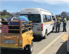  ?? Picture: SUPPLIED ?? ENFORCING THE LAW: Department of Transport MEC Weziwe Tikana assists law enforcemen­t officers at a roadblock to check whether motorists are complying with the rules of the road