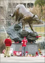  ?? Associated Press photo ?? People stop at a makeshift memorial for Washington State quarterbac­k Tyler Hilinski outside Martin Stadium in Pullman, Wash., Wednesday.