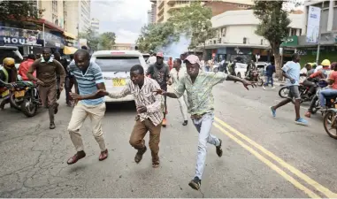  ?? PICTURE: AP ?? FREEDOM OF SPEECH: Supporters of opposition leader Raila Odinga flee from police firing tear gas, as they attempt to demonstrat­e in Nairobi, Kenya, yesterday.