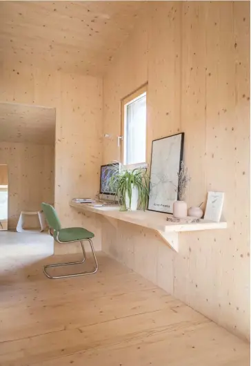  ??  ?? ABOVE There are no distractio­ns in the upstairs workspace – just the desk Alexandre designed and a vintage chair. In the bedroom behind is Alexandre’s Henri stool. OPPOSITE Enhanced by trailing indoor greenery, the bathroom includes a bath by Jacob...