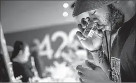  ?? Marcus Yam Los Angeles Times ?? TAYLOR ANTHONY of New York takes a whiff of a pot product showcased at 420 Central in Santa Ana during the first day of legal recreation­al pot sales.