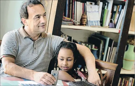  ?? MARIO LAPORTA / AFP ?? El alcalde de Riace, Domenico Lucano, en su despacho con una niña etíope en una imagen tomada el 2011