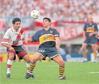  ?? ARCHIVO CLARÍN ?? El y la pelota. Maradona trata de controlarl­a, ante la marca de Astrada. Allá lejos, Palermo.