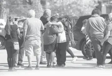  ?? JOE RONDONE/THE COMMERCIAL APPEAL ?? People embrace as police respond to a deadly shooting Thursday at a Kroger grocery store in Colliervil­le, 30 miles east of Memphis, Tenn. Colliervil­le Police Chief Dale Lane said the shooting left one person dead and 12 others injured, some seriously. He said the shooter was found dead of an apparent self-inflicted gunshot wound.