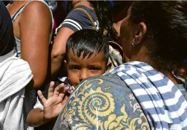  ??  ?? Famílias vindas de Honduras esperam para cruzar a fronteira entre Guatemala e México em Tecún Umán