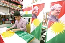  ??  ?? A man sewing an Iraqi Kurdish flag bearing a portrait of Iraqi Kurdistan President Massoud Barzani, in Erbil, the capital of the autonomous Kurdish region of northern Iraq. (AFP)