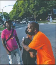  ??  ?? Demetrius Mingo (right), an outreach worker with the Target Area Developmen­t Corporatio­n, a nonprofit group addressing stubborn local problems, embraces an old friend as neighborin­g blocks attend a “peace picnic” in the Auburn Gresham neighborho­od.