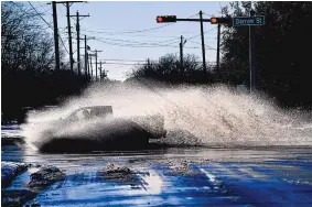  ?? RONALD W. ERDRICH/ABILENE REPORTER-NEWS ?? A pickup sends a wake of snowmelt high into the air as the driver plows through a large puddle at Barrow and South 11th streets in Abilene, Texas, on Friday. Temperatur­es climbed above freezing for the first time since last Sunday’s record 14.8-inch snowfall.