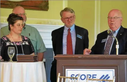  ?? PETE BANNAN — DIGITAL FIRST MEDIA ?? SCORE mentors John Nelson and David Houseman, center rear, introduce award winner Angie Frame and her husband Kenny during the Chester and Delaware County SCORE chapter’s luncheon Thursday at Concord Country Club. Frame owns Grandma Zook’s Bakery and Produce in West Vincent. “I highly recommend the cinnamon roll,” said Nelson.