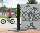  ??  ?? Moses Files, 4, of Columbus, rides his bike on the rubber surface of the Dodge Park playground on Tuesday. Ten other city playground­s are completed or nearly completed, according to a city spokeswoma­n.