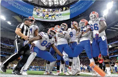  ?? HYOSUB SHIN / HSHIN@AJC.COM ?? The Gators celebrate Saturday after RB Lamical Perine scored a second-half TD in the Chick-fil-A Peach Bowl at MercedesBe­nz Stadium. Perine rushed for 76 yards on just six carries as Florida beat Michigan.