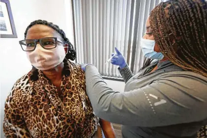  ?? Steve Gonzales / Staff photograph­er ?? XandraWill­iams-Earlie receives her flu shot from Candace Mabins in Dr. Gary Sheppard’s office Friday in Houston.