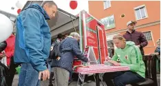  ??  ?? Zwischen den bunten Buden, Essenständ­en und Besuchern, die am Marktsonnt­ag in der Ulmer Straße umherschle­ndern, fällt der Blick unweigerli­ch auf Annamaria Savskai. Die 21-Jährige gehört zum slowenisch­en Kultur- und Sportverei­n Augsburg, kurz Drava. Heute marschiert FC Augsburg Profi Fredrik Jensen gab beim Marksonnta­g zahlreiche Autogramme für die Fans.