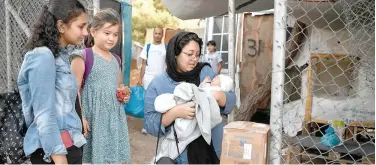  ?? Agence France-presse ?? ↑
A refugee carries her 16-day-old baby at the old Vathy camp, waiting to be transferre­d to the new Samos RIC on Monday.