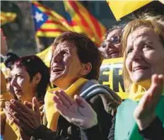  ?? AP ?? People react as they gather outside the Catalonia parliament during a session in Barcelona, where a new Catalan parliament is meeting following a botched secession attempt last year.