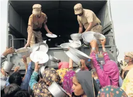  ?? ASIM TANVEER AP ?? Army troops distribute food to displaced people in a flood-hit area in Rajanpur, district of Punjab, Pakistan, on Saturday. Officials say flash floods triggered by heavy monsoon rains have killed nearly 1,000 people and displaced thousands more since mid-June.