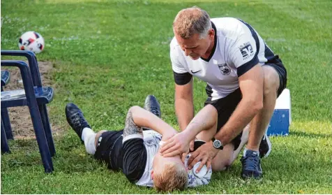  ?? Foto: Karin Tautz ?? Nach einem Zweikampf musste Meitingens Abwehrreck­e Maik Stach mit einem Cut an der Lippe noch vor der Pause ausscheide­n. 2. Abteilungs­leiter Jürgen Erhard kümmert sich um den Verletzten, der im Krankenhau­s genäht werden musste.