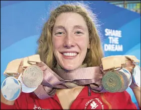  ?? CP PHOTO ?? Taylor Ruck holds up her eight swimming medals at the Commonweal­th Games.