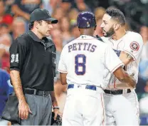  ?? Brett Coomer / Houston Chronicle ?? Astros third base coach Gary Pettis holds left fielder Marwin Gonzalez back after he was ejected in the fourth inning.