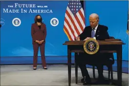  ?? EVAN VUCCI — THE ASSOCIATED PRESS ?? President Joe Biden signs an executive order on American manufactur­ing on Monday in Washington as Vice President Kamala Harris looks on.