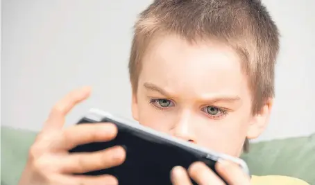  ?? Picture: Getty Images. ?? A young boy plays a hand-held games console. More than 80% of Scottish children exceed the recommende­d limit of two hours screen time per day.