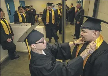  ?? Photograph­s by Irfan Khan Los Angeles Times ?? ANDREW SANCHEZ, left, adjusts the bow tie on fellow graduate Raymond Maldonado as they prepare for the Offender Mentor Certificat­ion Program graduation ceremony at the state prison in Lancaster.