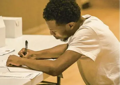  ?? KEVIN RICHARDSON/BALTIMORE SUN ?? Michael Custis, 22, a former squeegee worker from Baltimore, fills out an applicatio­n for employment at a job fair put on by the African American Male Engagement Baltimore network at the Reginald F. Lewis Museum.
