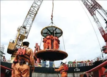  ?? WAHYOE BOEDIWARDH­ANA/THE JAKARTA POST ?? Pertamina Hulu Energi West Madura Offshore (PHE WMO) workers are moved in a personnel basket from a ship to the company’s oil rig off the coast of Madura Island in Indonesia’s East Java.
