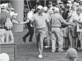  ?? ROB SCHUMACHER USA TODAY NETWORK ?? Tiger Woods greets fans on the way to the tee on the sixth hole Thursday during the first round of the Masters Tournament in Augusta, Georgia.