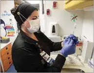  ??  ?? LVN Lucy Mata prepares Johnson & Johnson COVID-19 vaccines inside the Adventist Health mobile vaccinatio­n unit parked outside the Walmart at Fashion Plaza. The vaccinatio­n clinic was held Thursday morning.